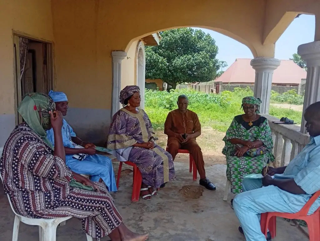 LHAAT members and community leaders seated in a circle on a veranda in Lere, Kaduna