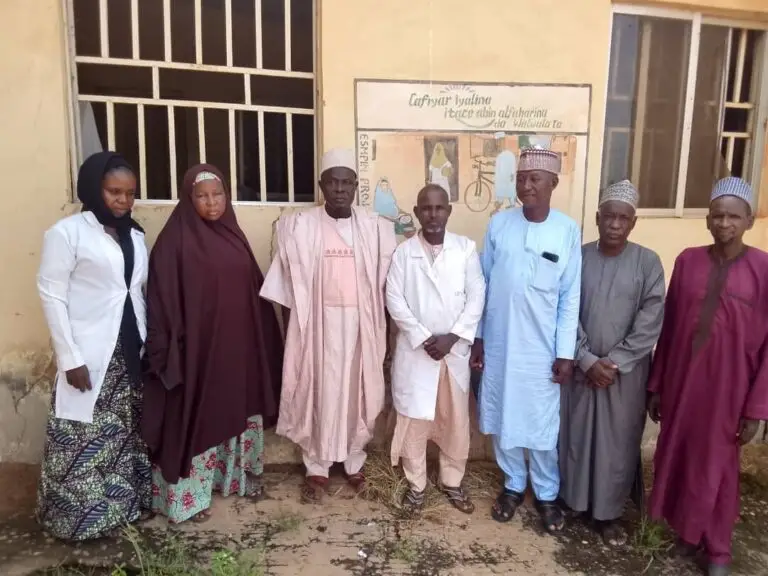 LHAAT members and health workers standing together outside a primary health centre in Bagudo, Kebbi
